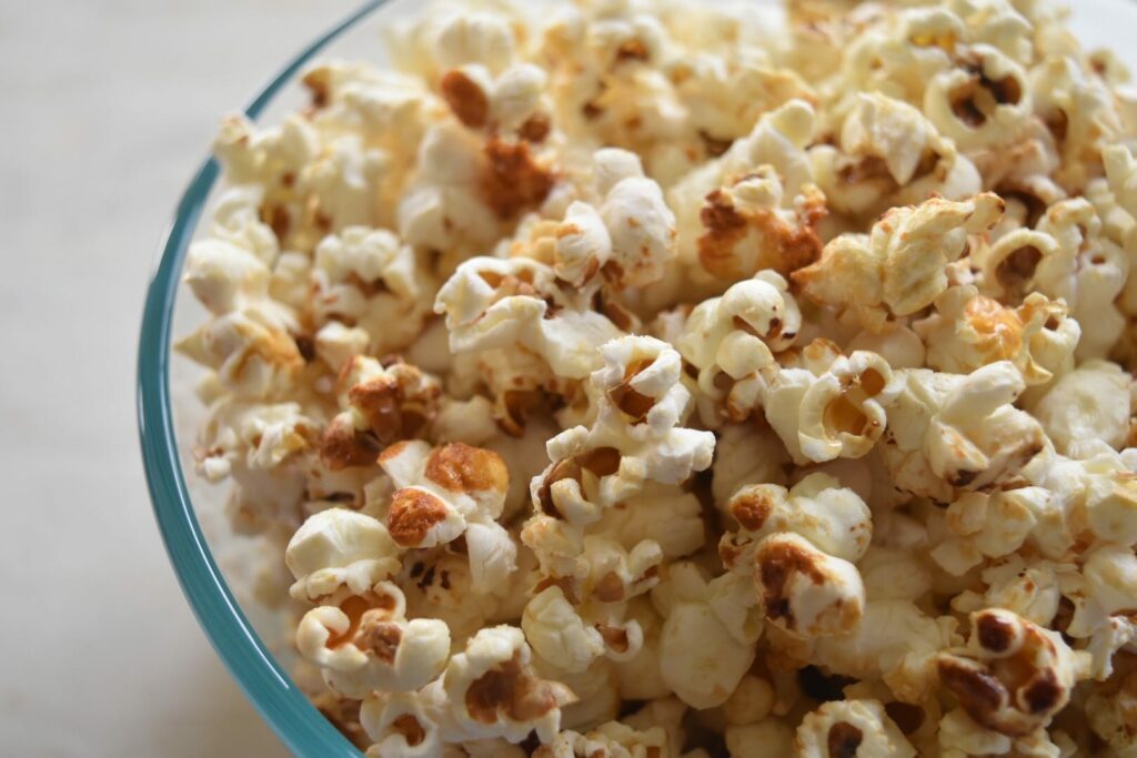 sweet and salty popcorn in glass bowl on white surface