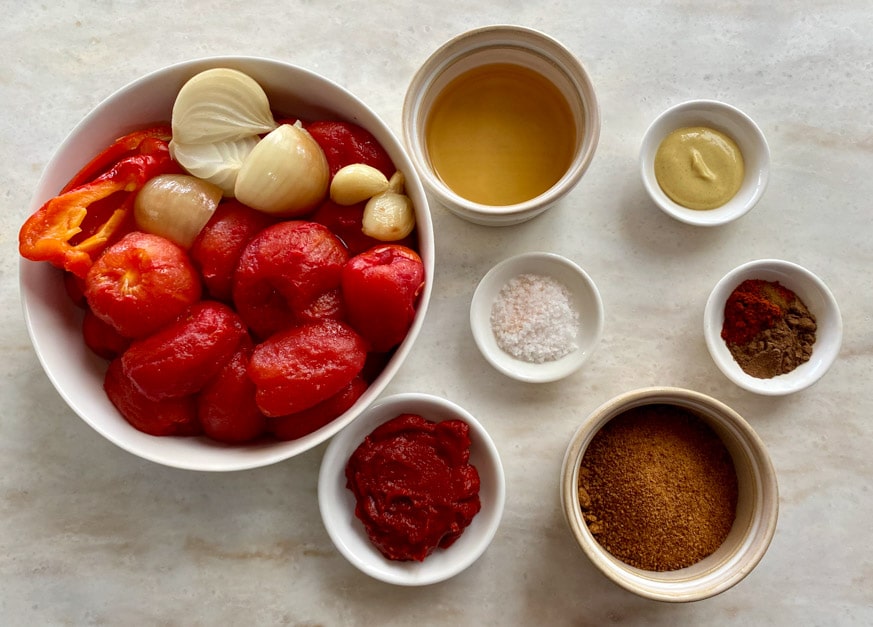 large bowl of tomatoes, smaller bowls of other thermomix tomato ketchup ingredients